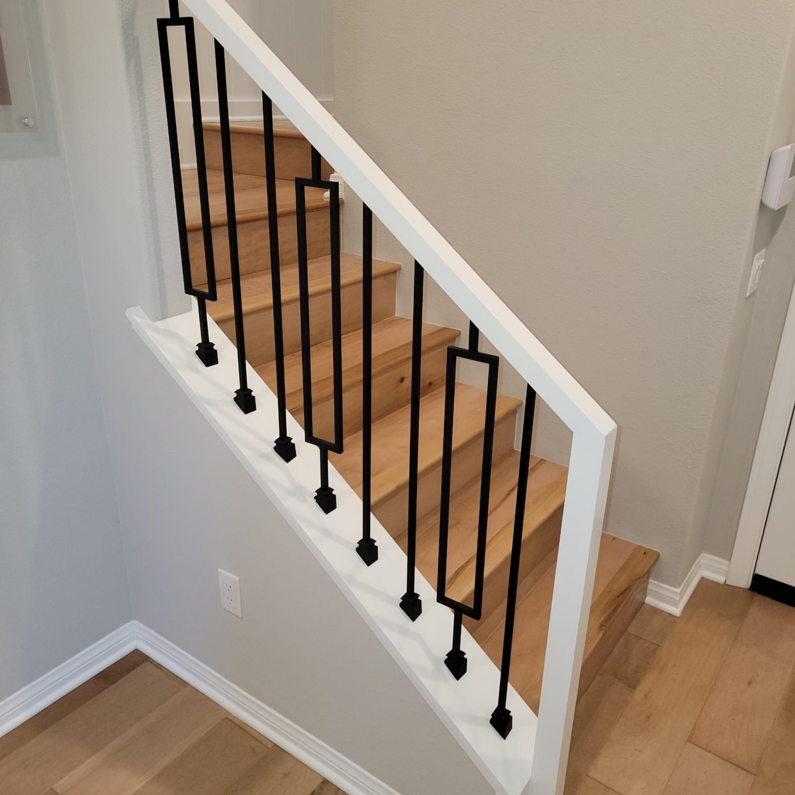 Stair landing with matching hardwood flooring and trim