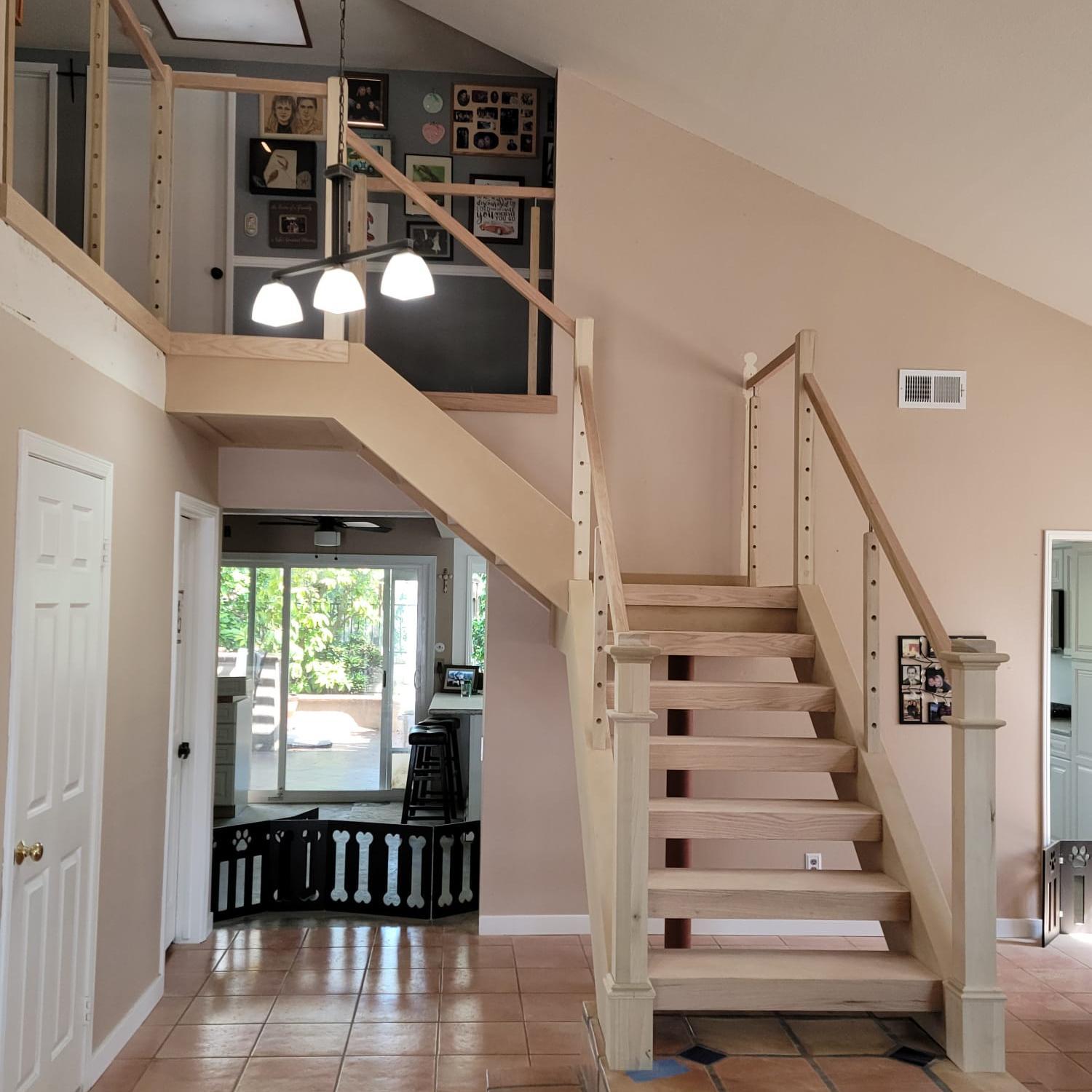 Finished stair remodel with brass-toned handrail